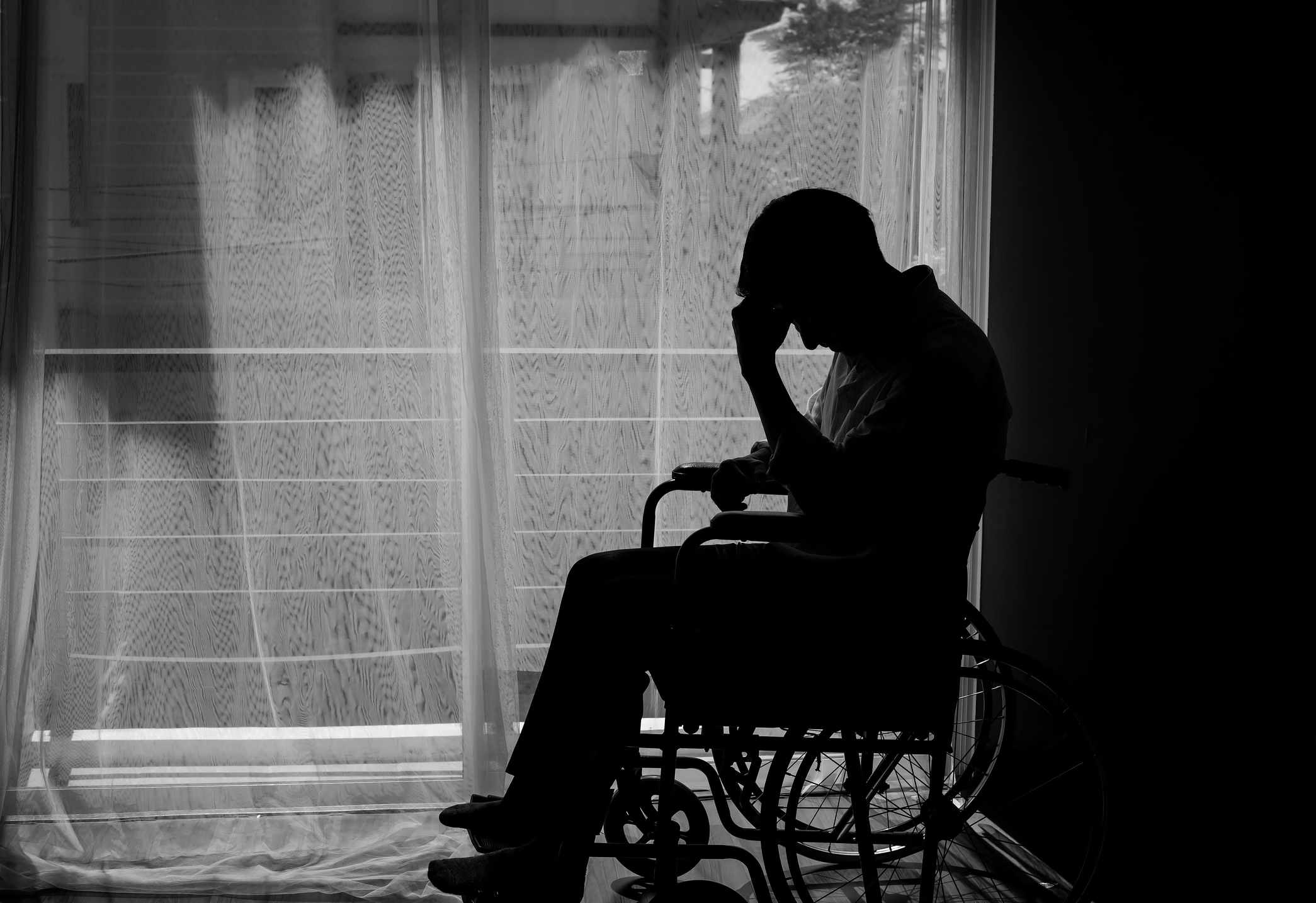 Фото сидящего человека у окна в больнице
