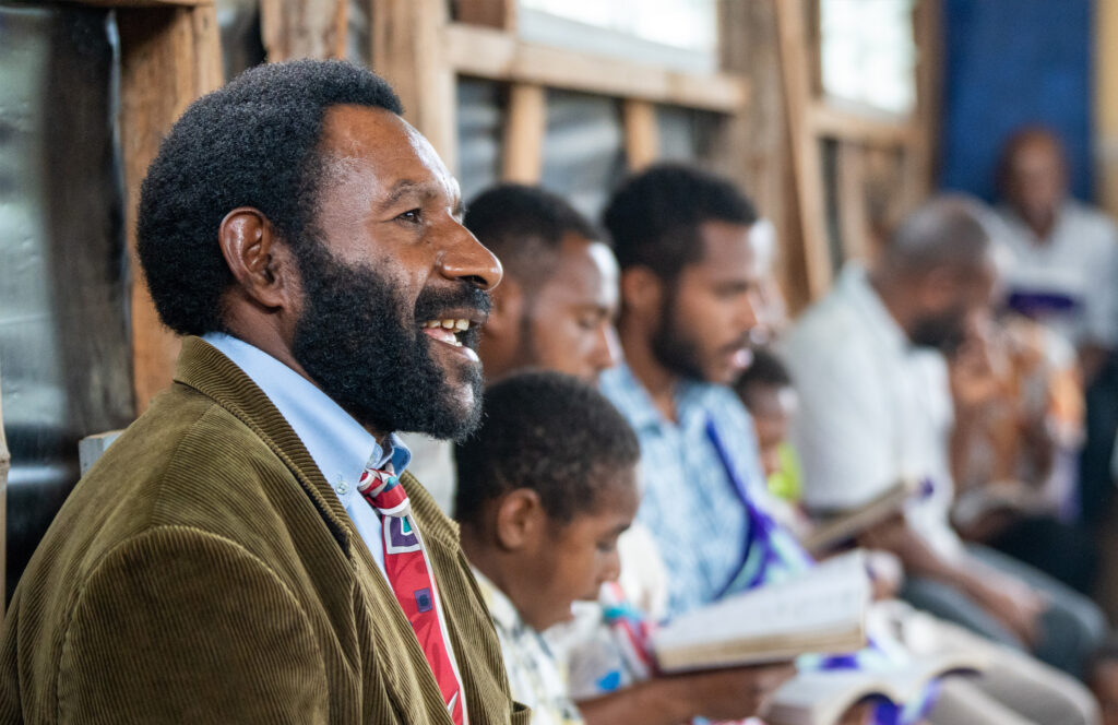 Believers holding open Bibles during a church service in Papua New Guinea