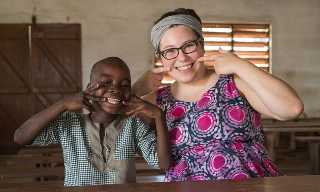 A missionary and a young student smiling together in a classroom