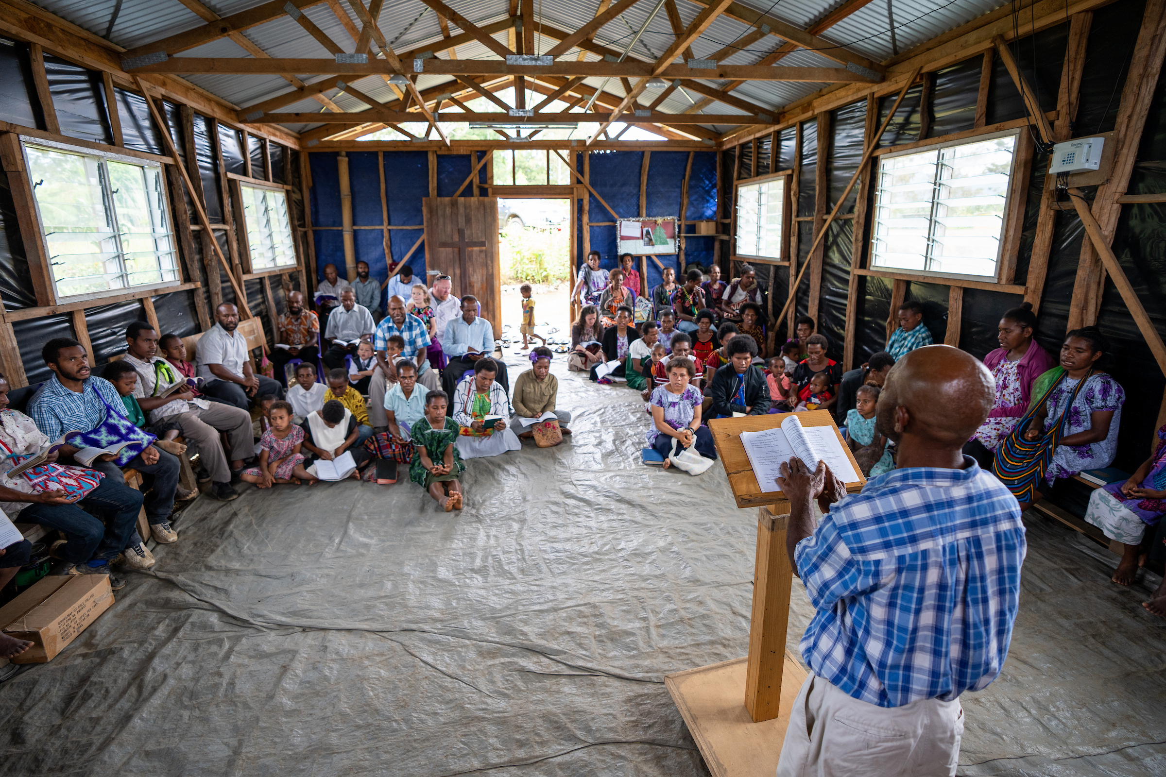 Local believer preaching to congregation in a Papua New Guinea village church